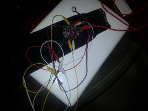 Image of a sleeve with alligator clips attached tio LilyPad and LEDs and pule sensor