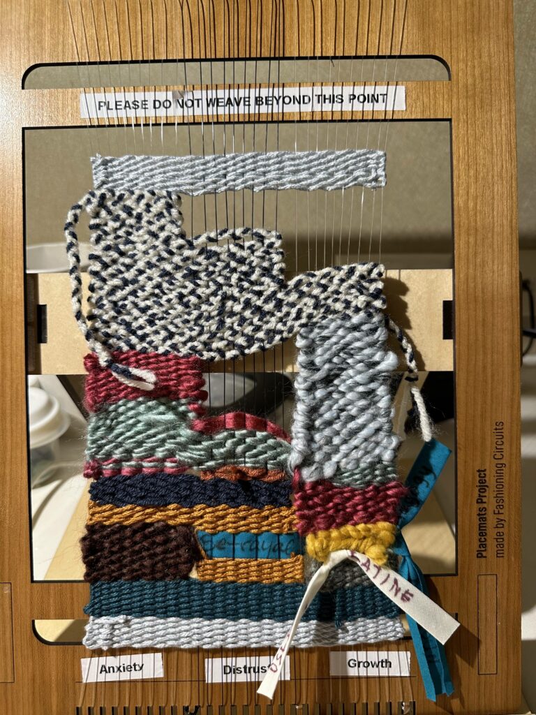 Closeup of one finished loom, showing creative weaving patterns and added keywords